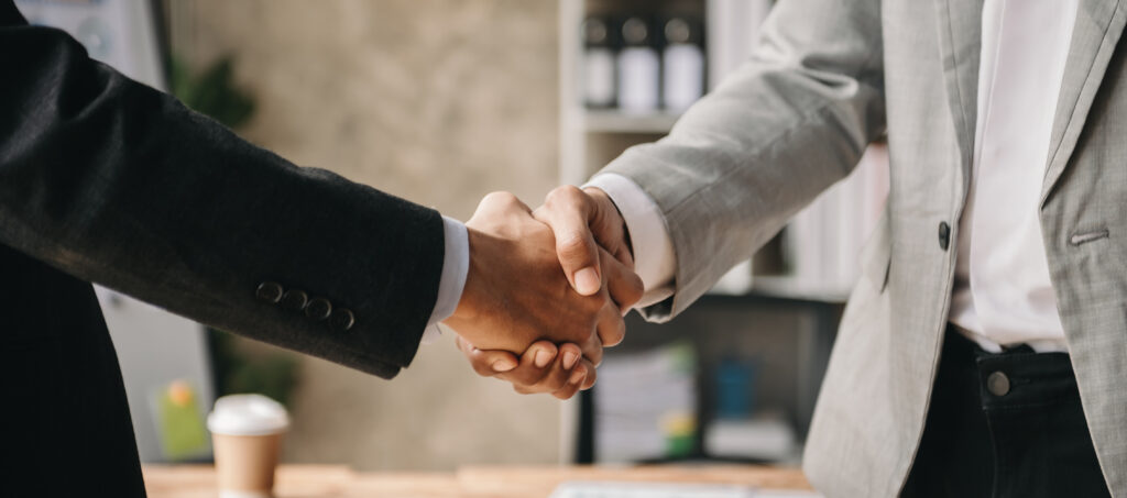 Two confident business man shaking hands during a meeting in the office, success, dealing, greeting and partner